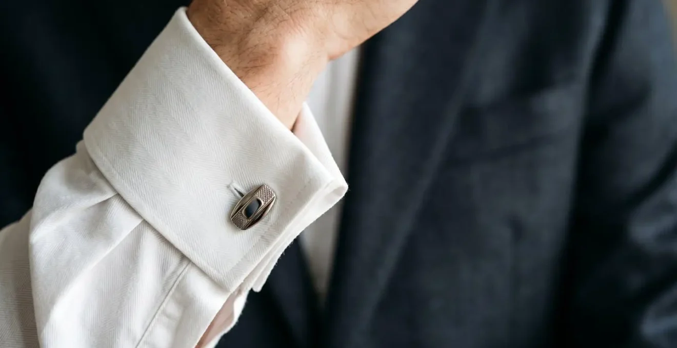 Détail élégant de boutons de manchette sur chemise à poignet mousquetaire porté avec costume