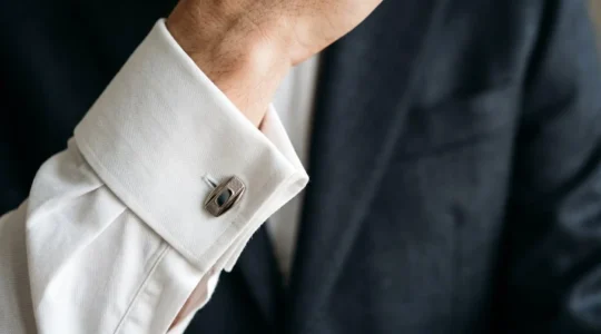 Détail élégant de boutons de manchette sur chemise à poignet mousquetaire porté avec costume