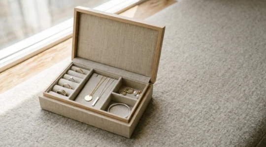 Détail d'une boîte à bijoux ouverte avec plusieurs pièces en or et argent disposées élégamment