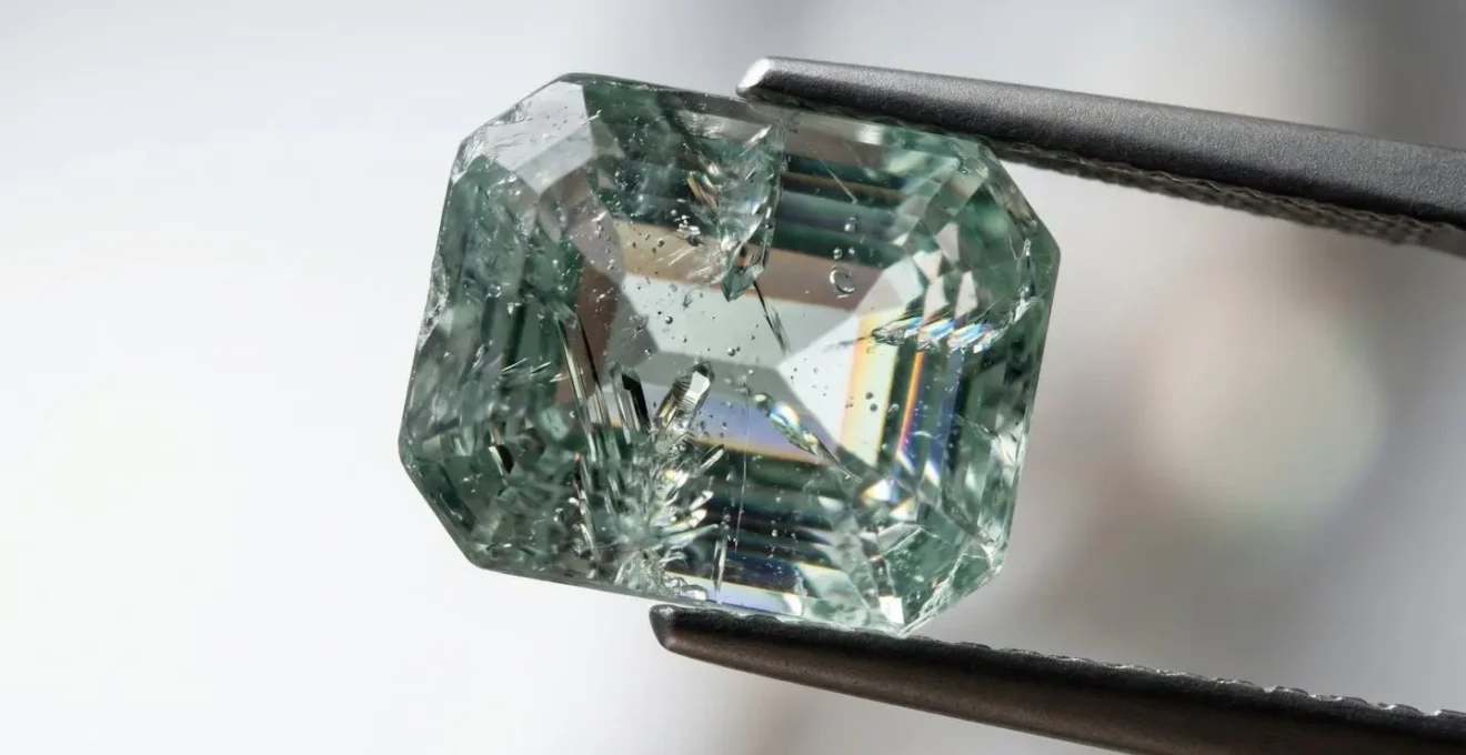 Inspection détaillée d'une pierre précieuse à la loupe de bijoutier révélant ses inclusions naturelles