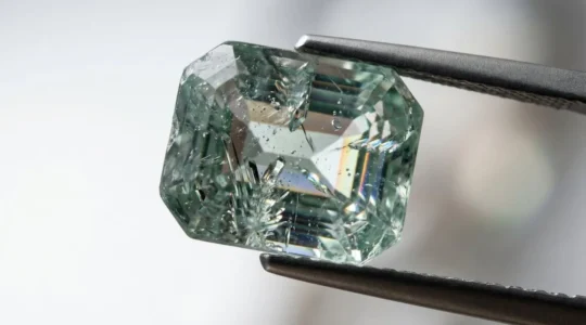 Inspection détaillée d'une pierre précieuse à la loupe de bijoutier révélant ses inclusions naturelles